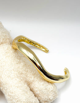 Non-tarnish sculptural wave statement bangle for women Dubai luxury fashion.