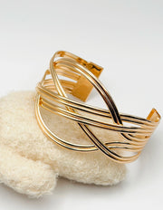 Non-tarnish sculptural overlapping gold bangle for women Dubai luxury fashion.