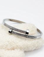 Silver bracelet with gemstones on a textured white surface