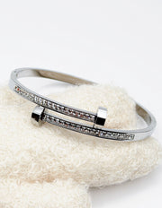 Silver bracelet with gemstones on a textured white surface