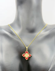 Gold necklace with a red flower pendant on a mannequin