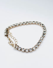 Silver bracelet with clear gemstones on a white background
