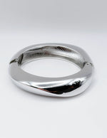 Silver bracelet on a light gray background