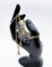 Close-up view of intricate butterfly filigree charms and CZ stone dangles on multi-strand bracelet.
