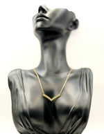 Waterproof gold geometric pavé pendant on white display.