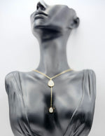 Waterproof non-tarnish artificial gold Y-drop necklace resting on taupe fabric.