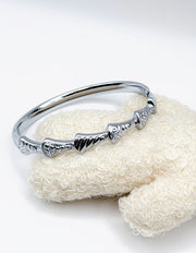 Hypoallergenic non-tarnish high polish silver rigid bangle with pave crystals.