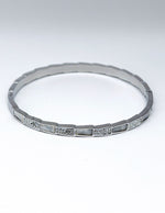 Silver bracelet with small stones on a white background
