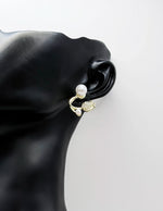 Close up of elegant imitation jewelry uae featuring a pavé crystal flower and faux pearls.